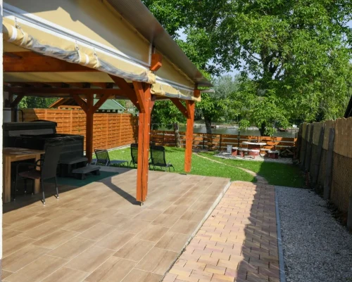 Gyermekbarát, vízpart felől is zárt kert sütögetővel, és a fedett, ponyvázott terasz alatti jacuzzival