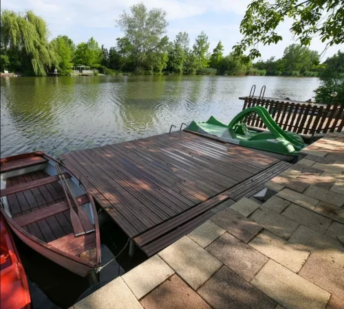 Kiépített vízpart stéggel, csónakkal és vízibiciklivel