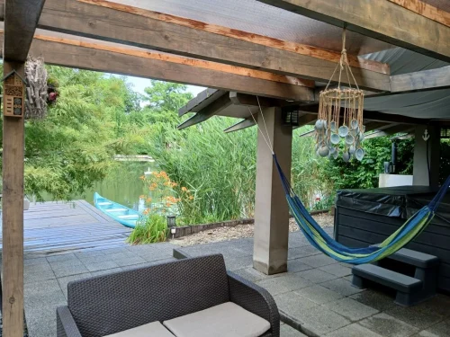 Vízpart melletti terasz jacuzzival és függőággyal