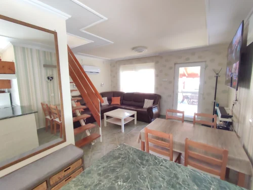 Étkező és nappali ágyazható sarokkanapéval, nagy méretű TV-vel