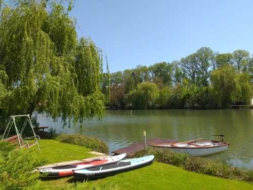 Elkerített vízpart stéggel csónakkal, SUP-pal