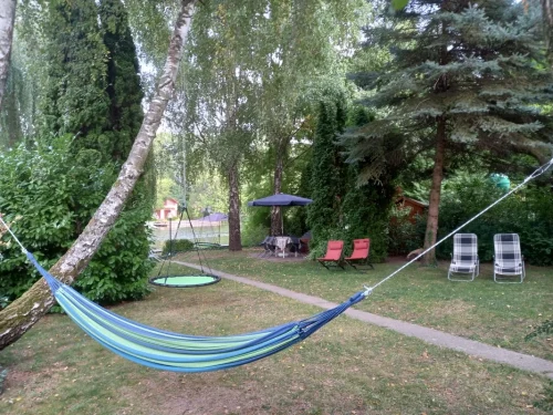 Gondozott kert napozóágyakkal, függőággyal, fészekhintával