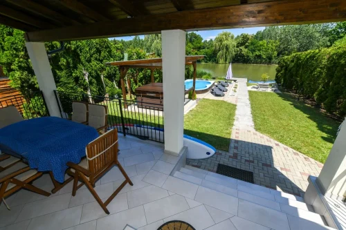 Fedett terasz, kilátással a kertre és vízpartra