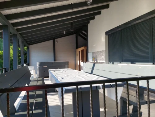 A fedett terasz alatt étkező, nyári konyha, jacuzzi és egy infraszauna is helyet kapott