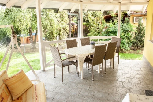 Fedett terasz kerti bútorokkal és hintaággyal