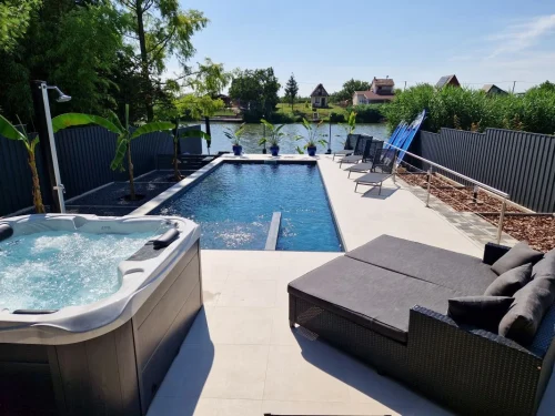 Jacuzzi, medence és napozóágyak kilátással a vízpartra