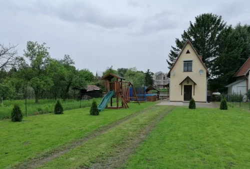 Nyaraló hátsó kertje trambulinnal, gyermekjátszótérrel
