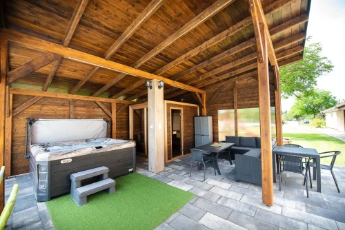 Fedett wellness részleg ötszemélyes jacuzzival, kombinált szaunával és polyrattan kerti bútorokkal