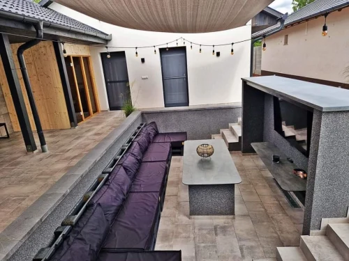 Süllyesztett közösségi tér a két ház között, nagy képernyős Tv-vel.