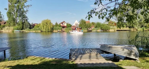 Vízpart stéggel és csónakkal