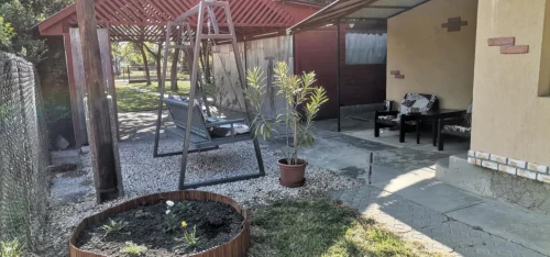 Épület melletti fedett tároló hintaággyal