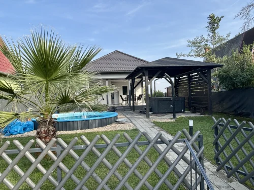 Kert napozóágyakkal és hidromasszázs fúvókákkal ellátott medencével valamint jacuzzival