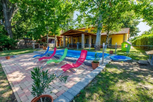 Napozóágyak és medence a kertben