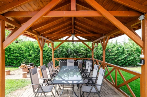 Fedett terasz nagy étkezőasztallal, bárhűtővel és csocsóval