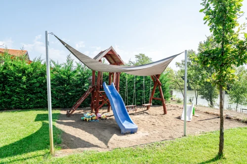 Játszótér kinti játékokkal és árnyékolóval