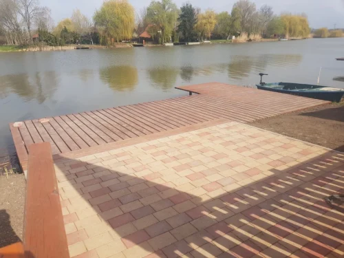 Elkerített vízpart stéggel, csónakkal