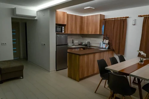 Teljeskörűen felszerelt konyha egy légtérben a nappalival és étkezővel