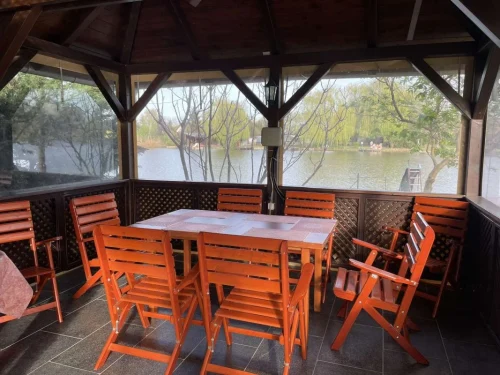 Fedett teraszon található kerti pad székekkel