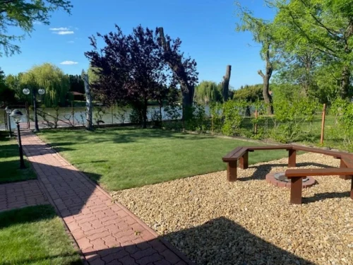 Kerti sütögető a vízparttól elkerített kertben