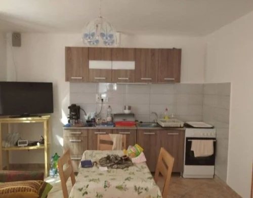 Felszerelt konyha egy térben a TV-vel ellátott nappalival