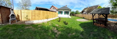 A nyaraló kertje sütögetővel és játszótérrel a háttérben