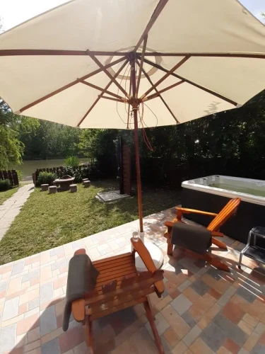 Kilátás a vízpartra a teraszról, jacuzzival és sütögetővel